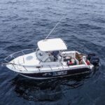 Boat ready for a shark fishing adventure with Shark.co fishing tour, led by Rob Clarke, surrounded by calm waters and a clear sky, capturing the excitement and anticipation of the trip in Central Newfoundland with Roland Bast Photo