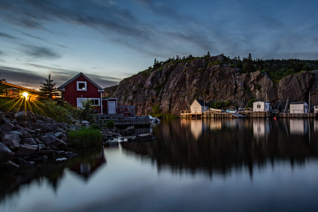 Quidi Vidi fishing village is bathed in a warm golden glow at sunset, highlighting the charming coastal scenery of eastern Newfoundland. Photography with Roland Bast Photo