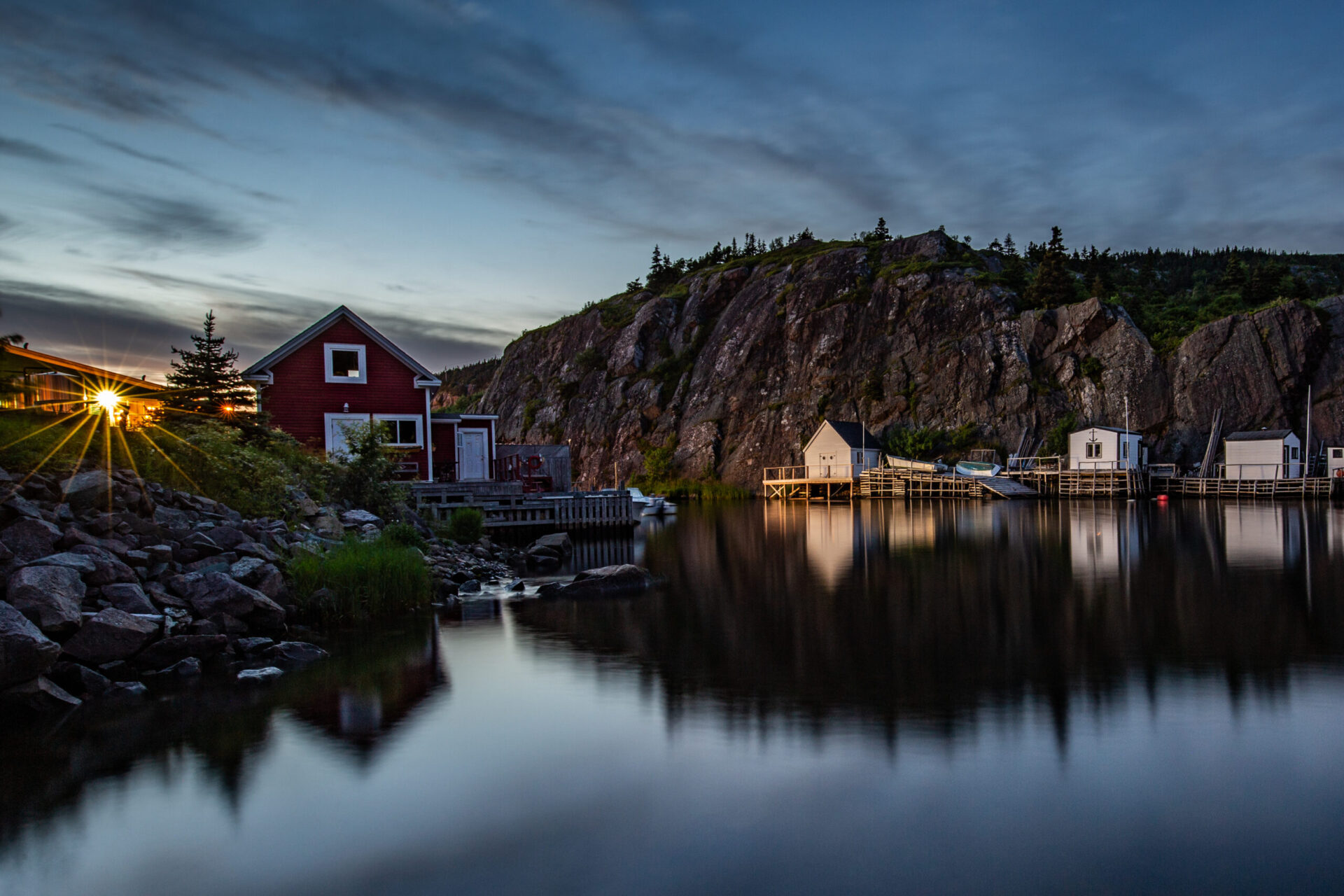 Quidi Vidi fishing village is bathed in a warm golden glow at sunset, highlighting the charming coastal scenery of eastern Newfoundland.